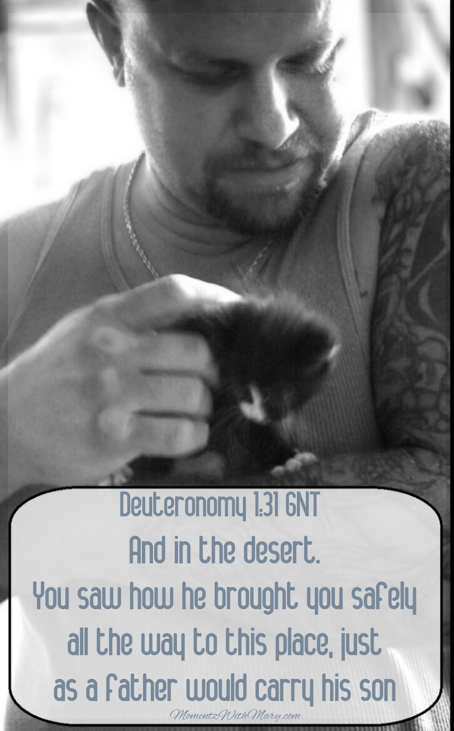 large man holding tiny kitten Deuteronomy 1:31 and in the desert. You saw how he brought you safely all the way to this place, just as a father would carry his son