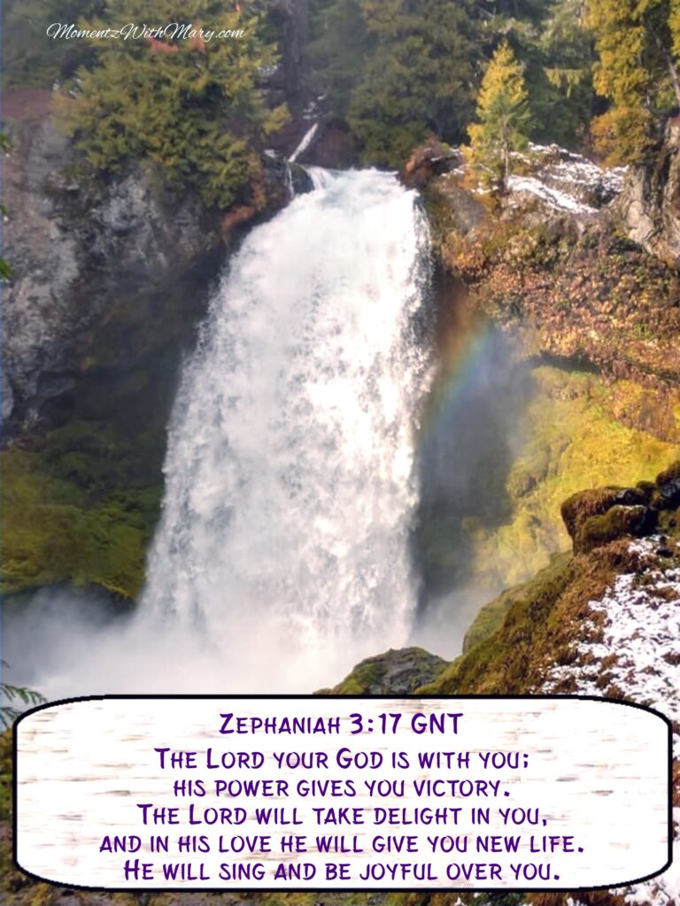large waterfall with rainbow in the mist surrounded by pine trees. Zephaniah 3:17
Good News Translation
The Lord your God is with you;
    his power gives you victory.
The Lord will take delight in you,
    and in his love he will give you new life.
He will sing and be joyful over you,
